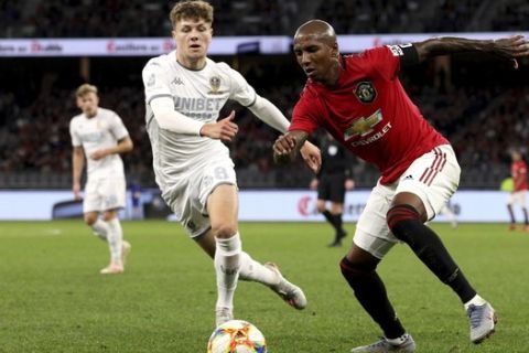 Ashley Young, right, of Manchester United and Jordan Stevens of Leeds United compete for the ball during their friendly soccer match in Perth, Australia, Wednesday, July 17, 2019. (Richard Wainwright/AAP Image via AP)