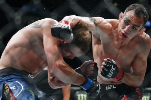 Tony Ferguson, right, punches Donald Cerrone, left, during their lightweight mixed martial arts bout at UFC 238, Saturday, June 8, 2019, in Chicago. (AP Photo/Kamil Krzaczynski)