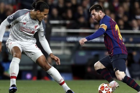 Liverpool's Virgil Van Dijk, left, vies for the ball with Barcelona's Lionel Messi during the Champions League semifinal, first leg, soccer match between FC Barcelona and Liverpool at the Camp Nou stadium in Barcelona Spain, Wednesday, May 1, 2019. (AP Photo/Joan Monfort)