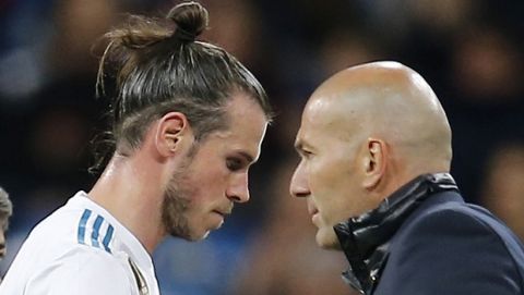 Real Madrid's Gareth Bale. left, shakes hands with Real Madrid's head coach Zinedine Zidane after being substituted during a Spanish La Liga soccer match between Real Madrid and Celta at the Santiago Bernabeu stadium in Madrid, Spain, Saturday, May 12, 2018. (AP Photo/Paul White)