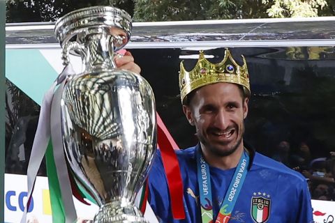 Italy's captain Giorgio Chiellini, wearing a crown and holding the trophy, and his teammates arrive at a hotel after returning from London, in Rome, Monday, July 12, 2021. Italy defeated England 3-2 in a penalty shootout after a 1-1 draw, to win the Euro 2020 soccer championships in a final played at Wembley stadium in London on July 11. (AP Photo/Riccardo De Luca)