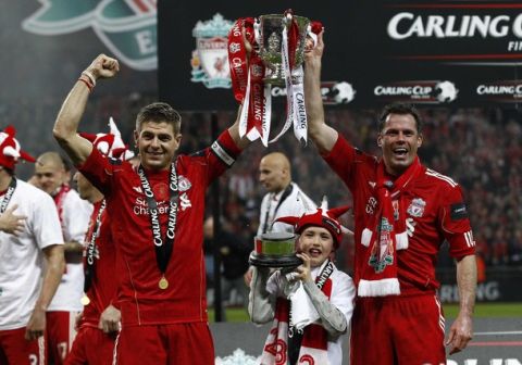 Liverpool's Steven Gerrard (L) celebrates with Jamie Carragher and son James with the trophy after their English League Cup final soccer match against Cardiff City at Wembley Stadium in London February 26, 2012. REUTERS/Eddie Keogh (BRITAIN - Tags: SPORT SOCCER CARLING CUP) FOR EDITORIAL USE ONLY. NOT FOR SALE FOR MARKETING OR ADVERTISING CAMPAIGNS. NO USE WITH UNAUTHORIZED AUDIO, VIDEO, DATA, FIXTURE LISTS, CLUB/LEAGUE LOGOS OR "LIVE" SERVICES. ONLINE IN-MATCH USE LIMITED TO 45 IMAGES, NO VIDEO EMULATION. NO USE IN BETTING, GAMES OR SINGLE CLUB/LEAGUE/PLAYER PUBLICATIONS