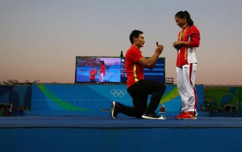 He Zi of China recieves a marriage proposal from Olympic diver Qin Kai of China after the medal ceremony for the 3m springboard.  REUTERS/Michael Dalder