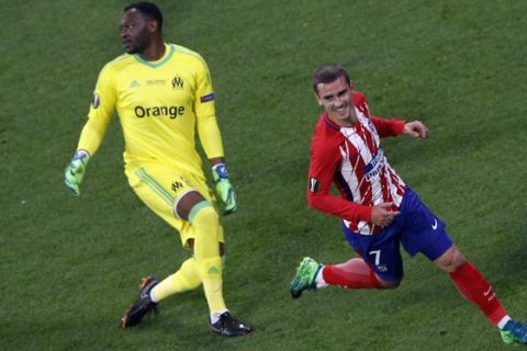 Atletico 's Antoine Griezmann, right, runs as Marseille's goalkeeper Steve Mandanda looks away after Griezmann scored his side opening goal during the Europa League Final soccer match between Marseille and Atletico Madrid at the Stade de Lyon outside Lyon, France, Wednesday, May 16, 2018. (AP Photo/Christophe Ena)
