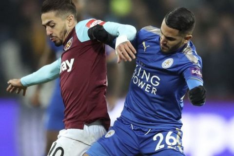 West Ham United's Manuel Lanzini, left  and Leicester City's Riyad Mahrez battle for the ball, during the English Premier League soccer match between West Ham United and Leicester City,  at the London Stadium, in London, Friday Nov. 24, 2017. (Adam Davy/PA via AP)
