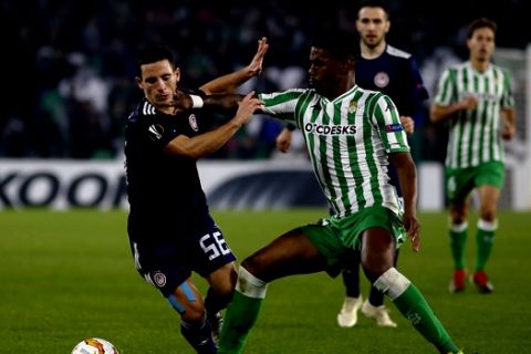 Olympiakos' Daniel Podence, left, duels for the ball with Betis' Junior Firpo during the Europa League Group F soccer match between Betis and Olympiakos at the Benito Villamarin Stadium in Seville, Spain, Thursday, Nov. 29, 2018. (AP Photo/Manuel Gomez)