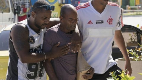 Sebastiao Rodrigues, center, uncle of the the young soccer player Samuel Rosa, one of the victims of a fire at a Brazilian soccer academy, grieves as he enter at a hotel in Rio de Janeiro, Brazil, Saturday, Feb. 9, 2019. A fire early Friday swept through the sleeping quarters of an academy for Brazil's popular professional soccer club Flamengo, killing 10 people and injuring three, most likely teenage players, authorities said. (AP Photo/Leo Correa)