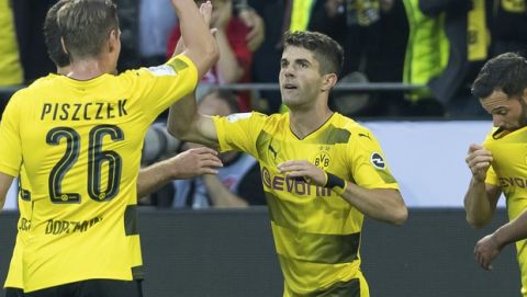 Dortmund's Christian Pulisic, second right, celebrates with teammate Lukasz Piszczek after scoring during the Supercup soccer final between FC Bayern Munich and Borussia Dortmund in the Signal-Iduna-Park in Dortmund, Germany, Saturday, Aug. 5 2017. (Marius Becker/dpa via AP)