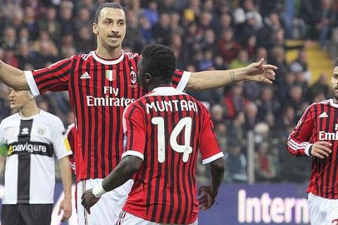 AC Milan's Zlatan Ibrahimovic celebrates with teammate Sulley Muntari after scoring against Parma during their Italian Serie A soccer match at the Tardini Stadium in Parma March 17, 2012. REUTERS/Giorgio Benvenuti (ITALY - Tags: SPORT SOCCER)