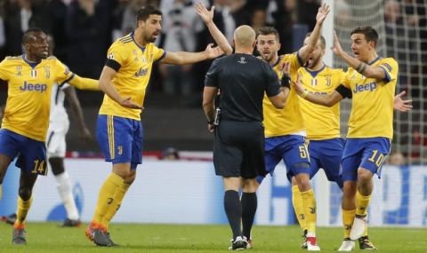 From left, Juventus' Blaise Matuidi, ad his teammates Sami Khedira, Miralem Pjanic and Paulo Dybala argue with referee Szymon Marciniak during the Champions League, round of 16, second-leg soccer match between Juventus and Tottenham Hotspur, at the Wembley Stadium in London, Wednesday, March 7, 2018. (AP Photo/Frank Augstein)