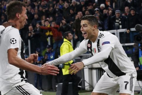 Juventus forward Mario Mandzukic, left, celebrates with his teammate Cristiano Ronaldo after scoring during the Champions League group H soccer match between Juventus and Valencia at the Allianz stadium in Turin, Italy, Tuesday, Nov. 27, 2018. (AP Photo/Antonio Calanni)