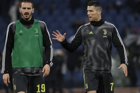 Juventus' Cristiano Ronaldo, right, talks with his teammate Leonardo Bonucci as they warm up prior to the start of the Serie A soccer match between Lazio and Juventus at the Olympic stadium, in Rome, Sunday, Jan. 27, 2019. (AP Photo/Gregorio Borgia)