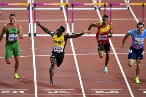 Jamaica's Omar McLeod, second left, celebrates as he wins the Men's 110 meters hurdles final at the World Athletics Championships in London Monday, Aug. 7, 2017. (AP Photo/Martin Meissner)