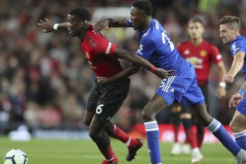 Manchester United's Paul Pogba, left vies for the ball with Leicester City's Wilfred Ndidi during the English Premier League soccer match between Manchester United and Leicester City at Old Trafford, in Manchester, England, Friday, Aug. 10, 2018. (AP Photo/Jon Super)