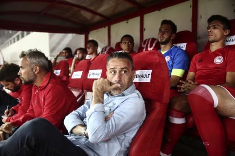 Olympiakos' coach Paulo Bento, center, waits for a Greek Super League soccer match against Veria to start at Karaiskakis stadium in Piraeus, near Athens, on Sunday, Sept. 11, 2016. The Greek league started on Saturday, after a two-week delay imposed by the government, which is struggling to tackle ongoing violence and alleged corruption in the sport. (AP Photo/Yorgos Karahalis)