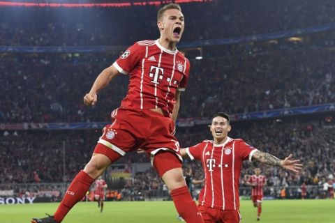 Bayern's Joshua Kimmich, left, celebrates his side's opening goal with team mate James during the semifinal first leg soccer match between FC Bayern Munich and Real Madrid at the Allianz Arena stadium in Munich, Germany, Wednesday, April 25, 2018. (AP Photo/Kerstin Joensson)