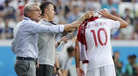 Poland head coach Adam Nawalka, left, gives directions to his players as Poland's Grzegorz Krychowiak cools off with some water during the group H match between Japan and Poland at the 2018 soccer World Cup at the Volgograd Arena in Volgograd, Russia, Thursday, June 28, 2018. (AP Photo/Eugene Hoshiko)