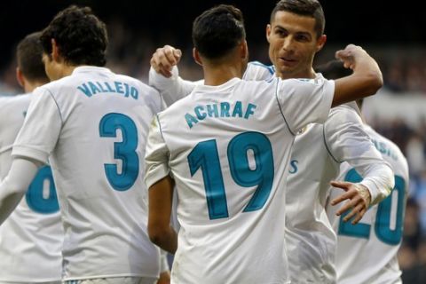 Real Madrid's Achraf, second right, celebrates with his teammate Cristiano Ronaldo after scoring his side's fifth goal against Sevilla during the Spanish La Liga soccer match between Real Madrid and Sevilla at the Santiago Bernabeu stadium in Madrid, Saturday, Dec. 9, 2017. (AP Photo/Francisco Seco)
