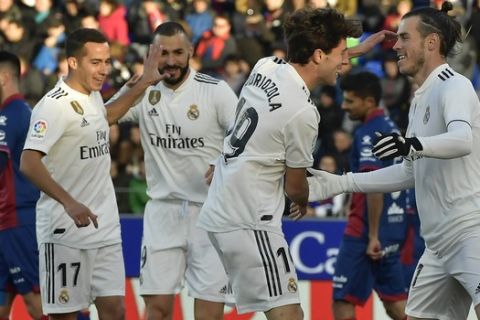 Real Madrid's Gareth Bale, right, celebrates with his fellow team after scoring against SD Huesca during the Spanish La Liga soccer match between Real Madrid and SD Huesca at El Alcoraz stadium, in Huesca, northern Spain, Sunday, Dec. 9, 2018. (AP Photo/Alvaro Barrientos)
