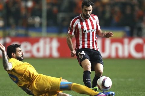 APOEL's Giorgos Merkis, left, challenges for the ball with Mikel Balenziaga of Athletic Bilbao during the Europa League round of 32 second leg soccer match between APOEL and Athletic Bilbao at the GSP stadium, in Nicosia, Cyprus, on Thursday, Feb. 23, 2017. (AP Photo/Petros Karadjias)