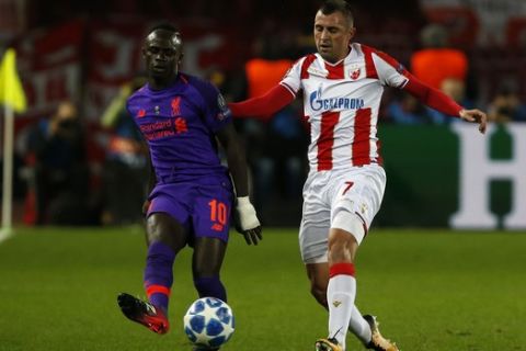 Liverpool midfielder Sadio Mane, left, passes as Red Star's Nenad Krsticic defends during the Champions League group C soccer match between Red Star and Liverpool at Rajko Mitic stadium in Belgrade, Tuesday, Nov. 6, 2018. (AP Photo/Darko Vojinovic)