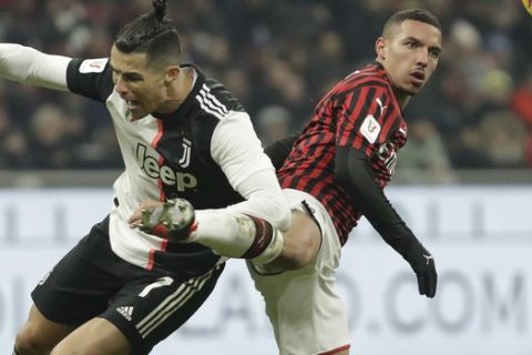 Juventus' Cristiano Ronaldo, left, fights for the ball with AC Milan's Ismael Bennacer during an Italian Cup soccer match between AC Milan and Juventus at the San Siro stadium, in Milan, Italy, Thursday, Feb. 13, 2020. (AP Photo/Luca Bruno)