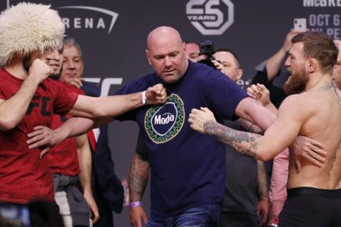 Dana White, center, keeps Khabib Nurmagomedov, left, and Conor McGregor away from each other during a ceremonial weigh-in for the UFC 229 mixed martial arts fight Friday, Oct. 5, 2018, in Las Vegas. (AP Photo/John Locher)
