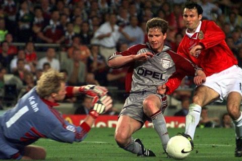 Bayern Munich's goalkeeper Oliver Kahn, left, makes a save at the feet of Manchester United's Ryan Giggs during the UEFA Champions Cup final at the Nou Camp Stadium in Barcelona Wednesday May 26, 1999. At center is Bayern's Michael Tarnat. (AP Photo/Adam Butler)