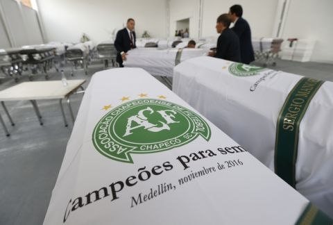 Funeral employees arrange caskets covered in white sheets with a Chapecoense soccer team logo that contain the remains of team members at the San Vicente funeral home in Medellin, Colombia, Friday, Dec. 2, 2016. The bodies of the Brazilian victims of this week's air tragedy will be repatriated later Friday to Chapeco, the hometown of the Brazilian soccer team. Members of the team and a group of journalists who perished on the flight were headed to the Copa Sudamericana finals when the plane ran out of fuel, crashing into the Andes outside Medellin.  (AP Photo/Fernando Vergara)