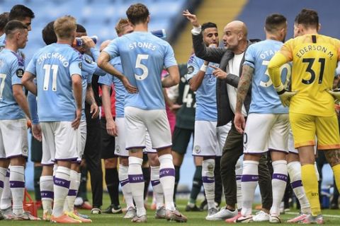 Manchester City's head coach Pep Guardiola talks to players during the English Premier League soccer match between Manchester City and Newcastle at the Ethiad Stadium in Manchester, England, Wednesday, July 8, 2020. (Oli Scarff/Pool via AP)