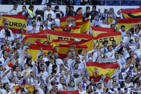 Real Madrid fans hold up Spanish national flags before the start of the Spanish La Liga soccer match between Real Madrid and Barcelona at the Santiago Bernabeu stadium in Madrid, Spain, Saturday, Dec. 23, 2017. (AP Photo/Paul White)