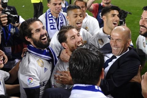 Real Madrid's head coach Zinedine Zidane celebrates with his players after winning a Spanish La Liga soccer match between Malaga and Real Madrid in Malaga, Spain, Sunday, May 21, 2017. Real Madrid wins the Spanish league for the first time in five years, avoiding its biggest title drought since the 1980s. (AP Photo/Daniel Tejedor)