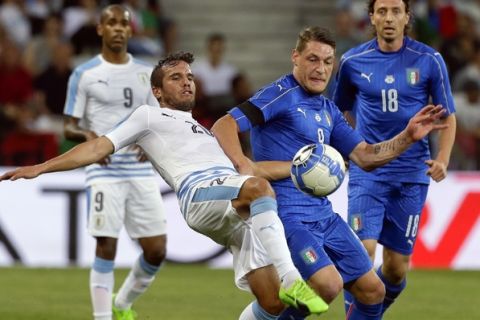 Uruguay's Alvaro Gonzalez, left, challenges Italy's Andrea Belotti during a friendly soccer match between Italy and Uruguay, at the Nice Allianz Riviera stadium, France, Wednesday, June 7, 2017. (AP Photo/Claude Paris)