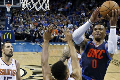 Oklahoma City Thunder guard Russell Westbrook shoots in front of Phoenix Suns guard Elie Okobo (2) and forward Ryan Anderson (15) in the first half of an NBA basketball game in Oklahoma City, Sunday, Oct. 28, 2018. (AP Photo/Sue Ogrocki)