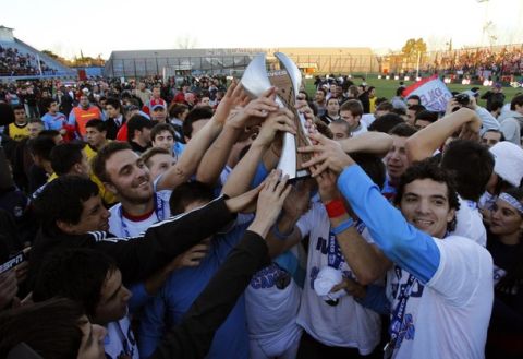 Arsenal's soccer players hold the trophy after they won the Argentine league title for the first time, after beating Belgrano 1-0 at home, on the final day of the Clausura championship in Buenos Aires June 24, 2012.        REUTERS/Stringer (ARGENTINA  - Tags: SPORT SOCCER)