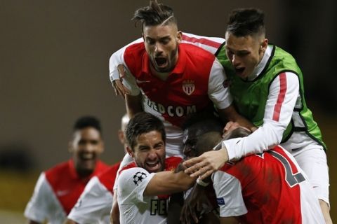 Monaco's Brazilian defender Fabinho (hidden) is congratulated by his teammates after scoring a goal during the UEFA Champions League football match AS Monaco (ASM) vs Zenit Saint-Petersburg, on December 9, 2014 at the Louis II stadium in Monaco. AFP PHOTO / VALERY HACHE        (Photo credit should read VALERY HACHE/AFP/Getty Images)