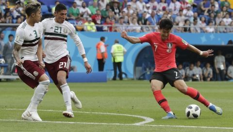 South Korea's Son Heung-min, challenges for the ball with Mexico's Carlos Salcedo, left, and Mexico's Edson Alvarez during the group F match between Mexico and South Korea at the 2018 soccer World Cup in the Rostov Arena in Rostov-on-Don, Russia, Saturday, June 23, 2018. (AP Photo/Lee Jin-man)