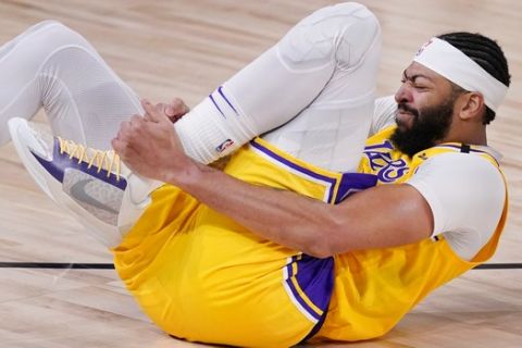 Los Angeles Lakers' Anthony Davis (3) grabs his ankle after a fall during the second half of an NBA conference final playoff basketball game against the Denver Nuggets Thursday, Sept. 24, 2020, in Lake Buena Vista, Fla. (AP Photo/Mark J. Terrill)