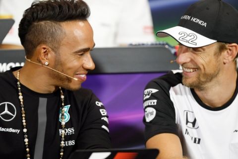 Mercedes driver Lewis Hamilton of Britain,  left, and McLaren driver Jenson Button of Britain, smile each other,  during an official press conference prior the Formula One Grand Prix,  at the Monaco racetrack, in Monaco, Wednesday, May 20, 2015. The Formula one race will be held on Sunday. (AP Photo/Claude Paris)