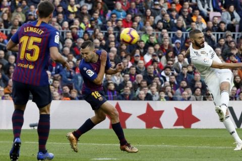 Real forward Karim Benzema, right, kicks the ball during the Spanish La Liga soccer match between FC Barcelona and Real Madrid at the Camp Nou stadium in Barcelona, Spain, Sunday, Oct. 28, 2018. (AP Photo/Joan Monfort)