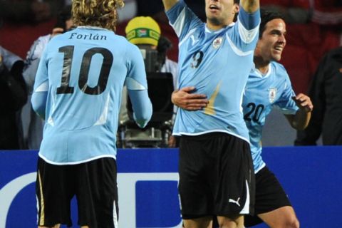 Uruguayan forward Luis Suarez (C) celebrates with teammates forward Diego Forlan (L) and midfielder Alvaro Gonzalez, after scoring against Peru, during the 2011 Copa America semi-final football match, at the Ciudad de La Plata stadium in La Plata, 59 Km south of Buenos Aires, on July 19, 2011.     AFP PHOTO / JUAN MABROMATA (Photo credit should read JUAN MABROMATA/AFP/Getty Images)