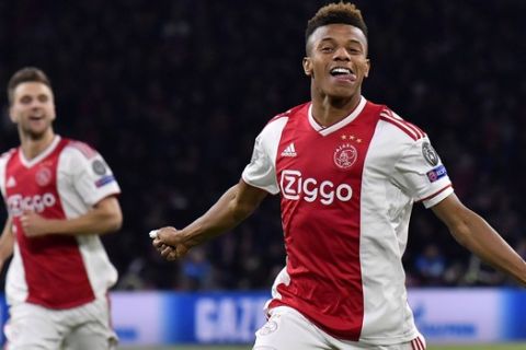 Ajax's David Neres, right, celebrates after scoring his side's opening goal during the Champions League quarterfinal, first leg, soccer match between Ajax and Juventus at the Johan Cruyff ArenA in Amsterdam, Netherlands, Wednesday, April 10, 2019. (AP Photo/Martin Meissner)