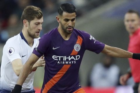 Tottenham's Ben Davies, left, fights for the ball with Manchester City's Riyad Mahrez as Tottenham manager Mauricio Pochettino, right, watches during the English Premier League soccer match between Tottenham Hotspur and Manchester City at Wembley stadium in London, England, Monday, Oct. 29, 2018. (AP Photo/Tim Ireland)
