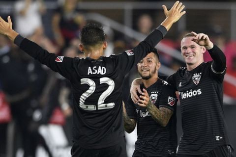 D.C. United midfielder Luciano Acosta (10) celebrates his goal with forward Wayne Rooney (9) and Yamil Asad (22) during the second half of an MLS soccer match against Orlando City, Sunday, Aug. 12, 2018, in Washington. D.C. United won 3-2. (AP Photo/Nick Wass)