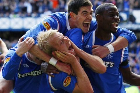 Rangers' Steven Naismith(C) gestures to Celtic fans as he celebrates with his teammates during their Scottish Premier League 'Old Firm' soccer match at Ibrox stadium in Glasgow, Scotland September 18, 2011. REUTERS/David Moir (BRITAIN - Tags: SPORT SOCCER)