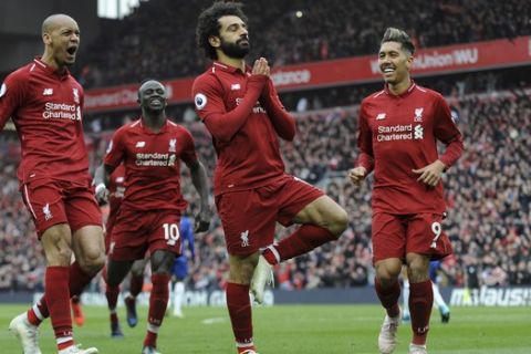 Liverpool's Mohamed Salah, center, celebrates with teammates after scoring his side's second goal during the English Premier League soccer match between Liverpool and Chelsea at Anfield stadium in Liverpool, England, Sunday, April 14, 2019. (AP Photo/Rui Vieira)