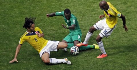 Colombia's Abel Aguilar, left, and Colombia's Victor Ibarbo, right, battle for the ball with Ivory Coast's Cheik Tiote during the group C World Cup soccer match between Colombia and Ivory Coast at the Estadio Nacional in Brasilia, Brazil, Thursday, June 19, 2014.  (AP Photo/Themba Hadebe)