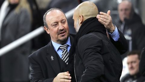 Newcastle United manager Rafael Benitez, left, greets Manchester City manager Pep Guardiola during their English Premier League soccer match at St James' Park, Newcastle, England, Wednesday, Dec. 27, 2017. (Owen Humphreys/PA via AP)