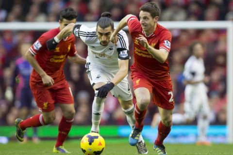 Liverpool's Joe Allen, right, keeps the ball from Swansea City's Chico, centre, as Philippe Coutinho looks on during their English Premier League soccer match at Anfield Stadium, Liverpool, England, Sunday Feb. 23, 2014. (AP Photo/Jon Super)    