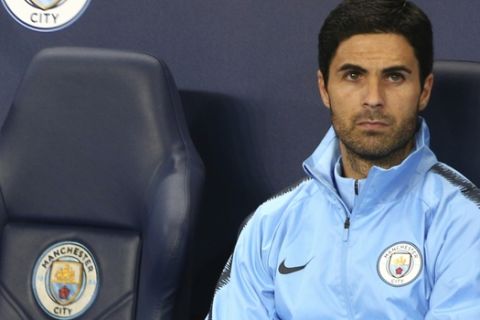 Manchester City's assistant coach Mikel Arteta sits next to an empty seat ahead of the Champions League Group F soccer match between Manchester City and Lyon at the Etihad stadium in Manchester, England, Wednesday, Sept. 19, 2018. (AP Photo/Dave Thompson)